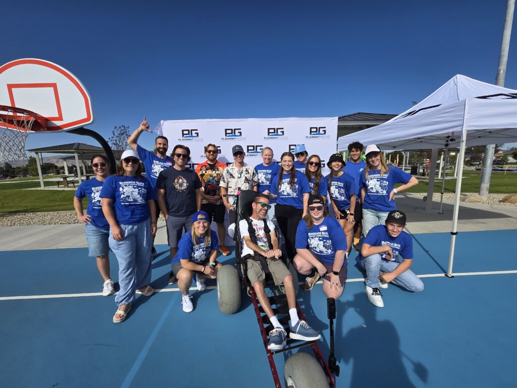 group photo of volunteers and participants at an adaptive obstacle course.